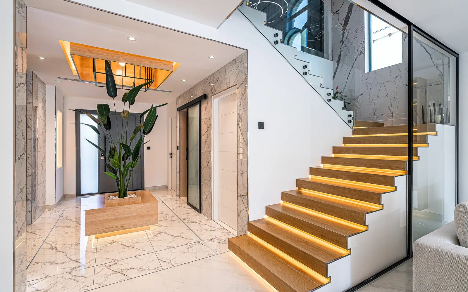 Living room with entertainment wall and staircase in a renovated villa
