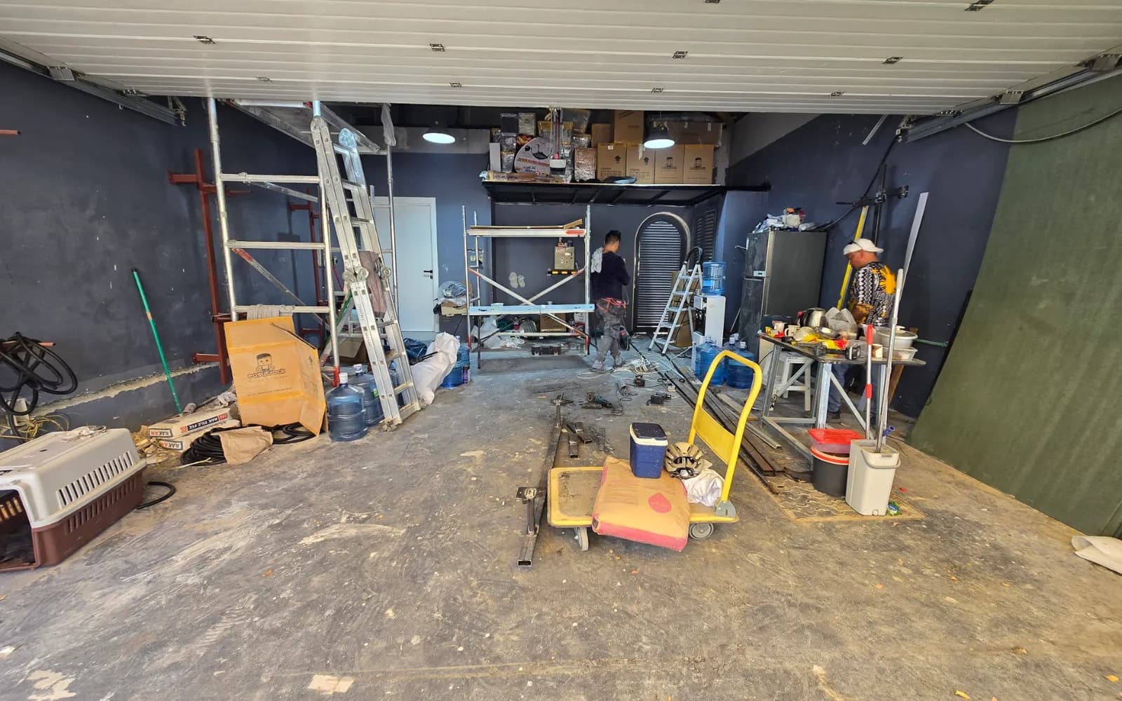 A villa garage during the strip out, with scaffolding, tools and stored boxes